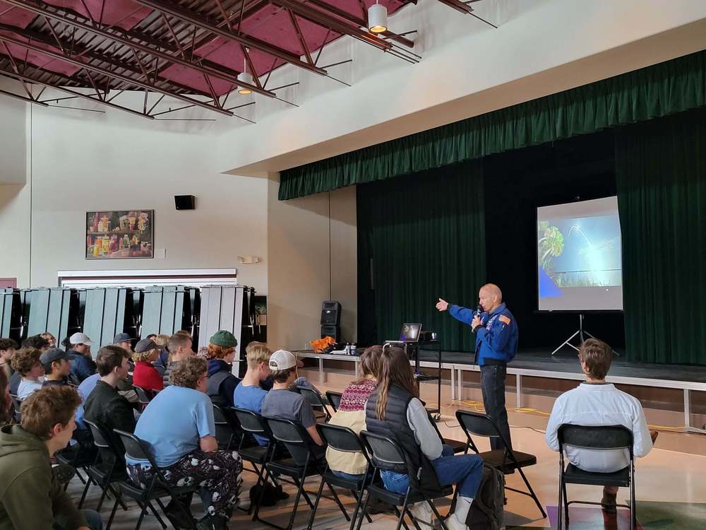 astronaut giving a presentation in front of students in gym