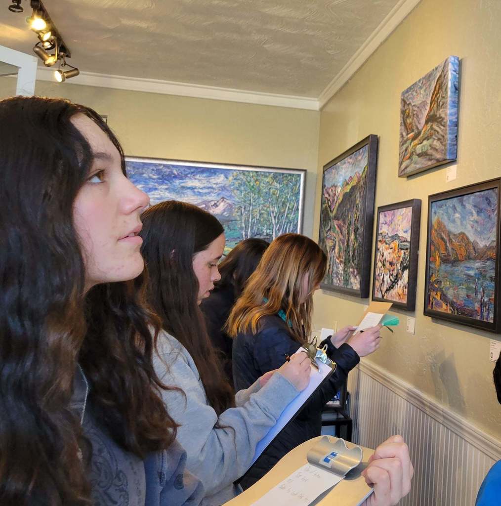 students in art gallery looking at paintings of landscapes