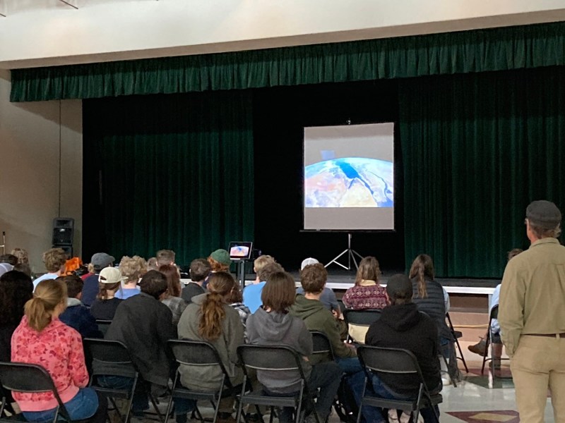 students watching video footage of a trip in space around earth