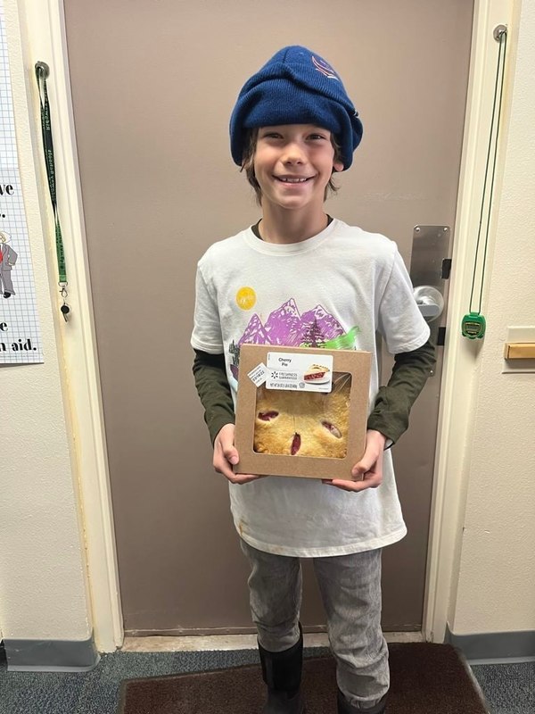 student smiling holding pie for pi day